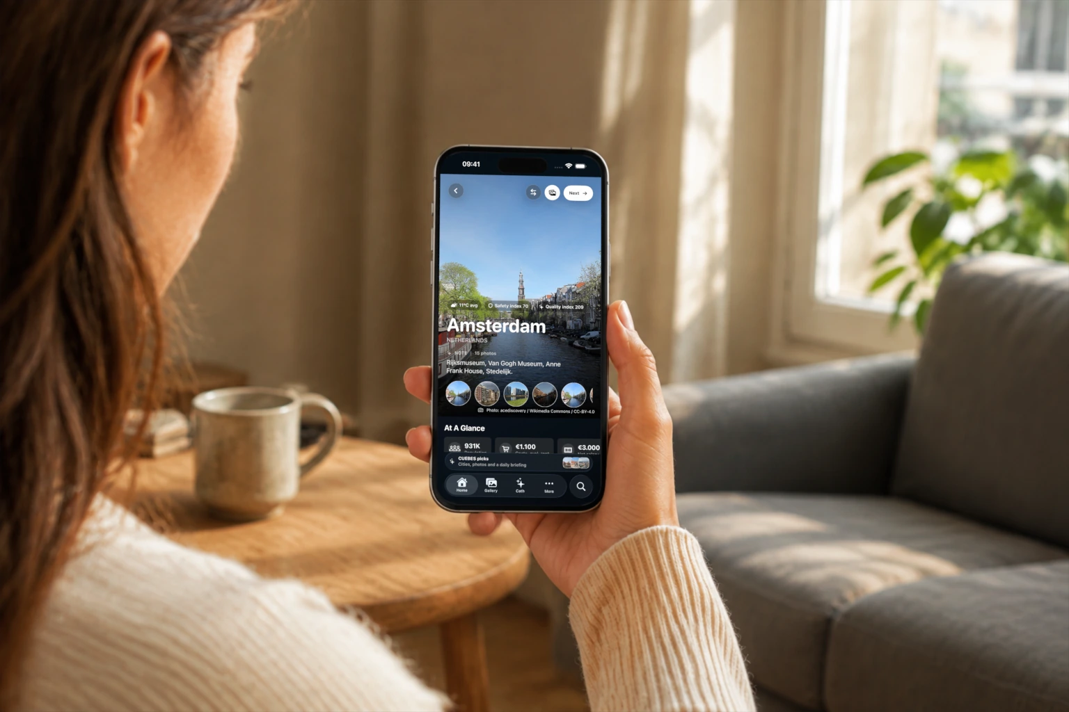 A person holds an iPhone displaying the mEUvy Amsterdam place page