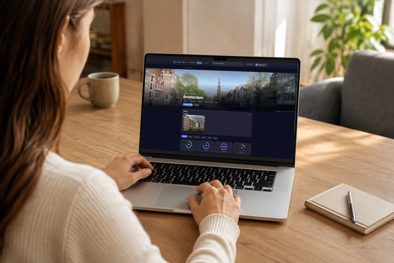 A person uses mEUvy web on a MacBook in a sunlit room